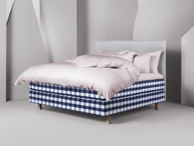 Letto Eala moderno con piedi in legno e testiera imbottita di Hästens